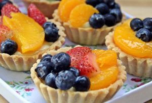 Søte terter med vaniljekrem bær og frukt